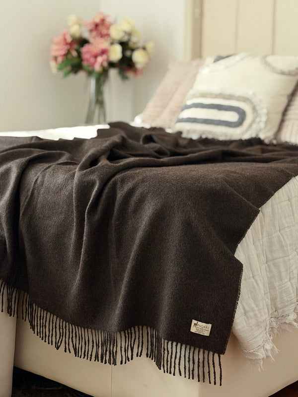 Andean brown baby alpaca throw draped over the foot of a bed